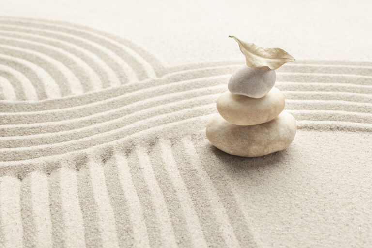 Stacked zen marble stones sand background in mindfulness concept